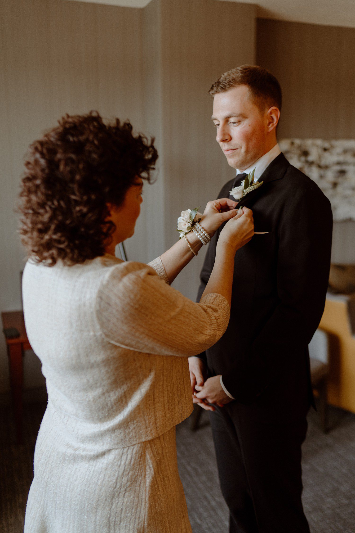Mom pinning on son's wedding boutoneirre