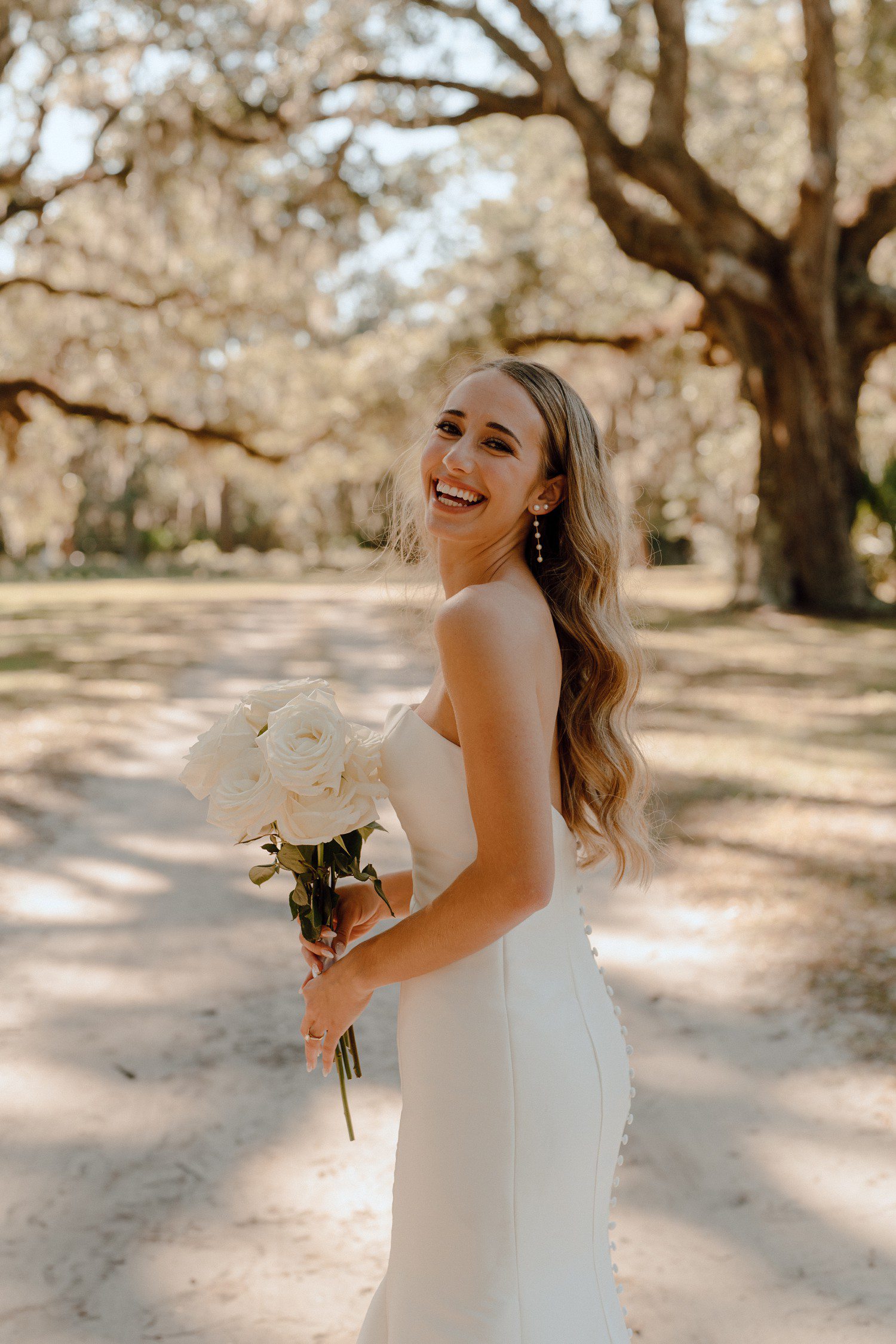 Bride Smiling holding white rose bouquet 