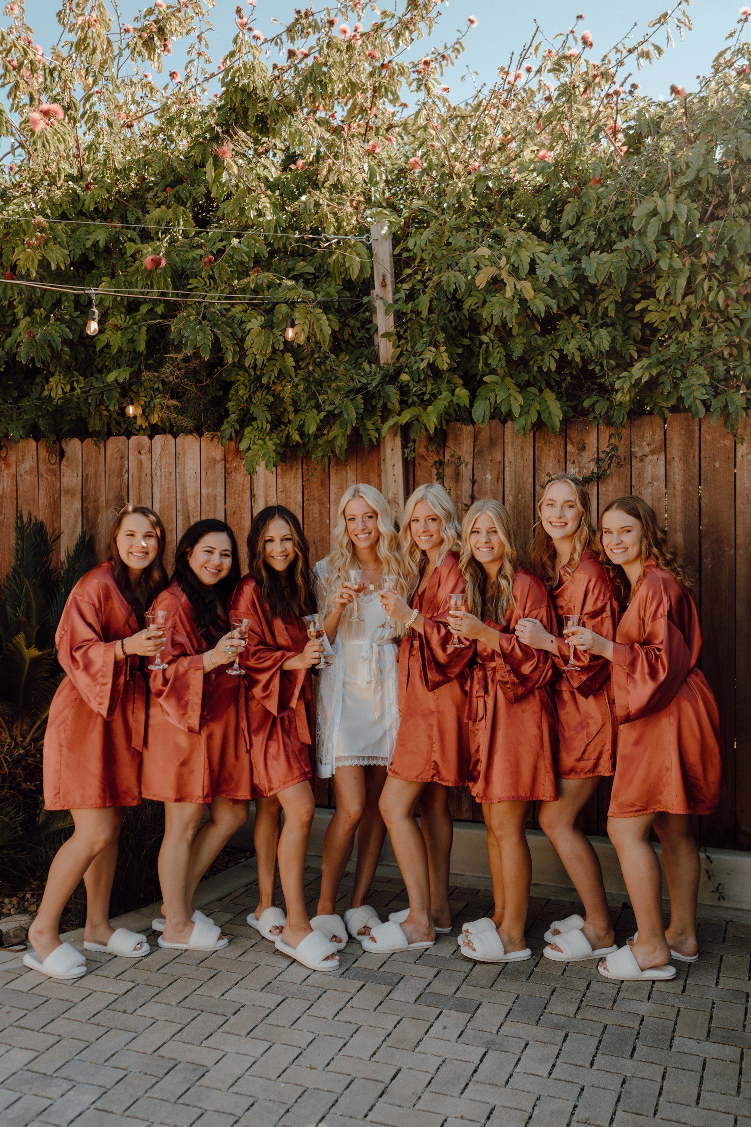 Bride and bridesmaids in burnt orange robes getting ready