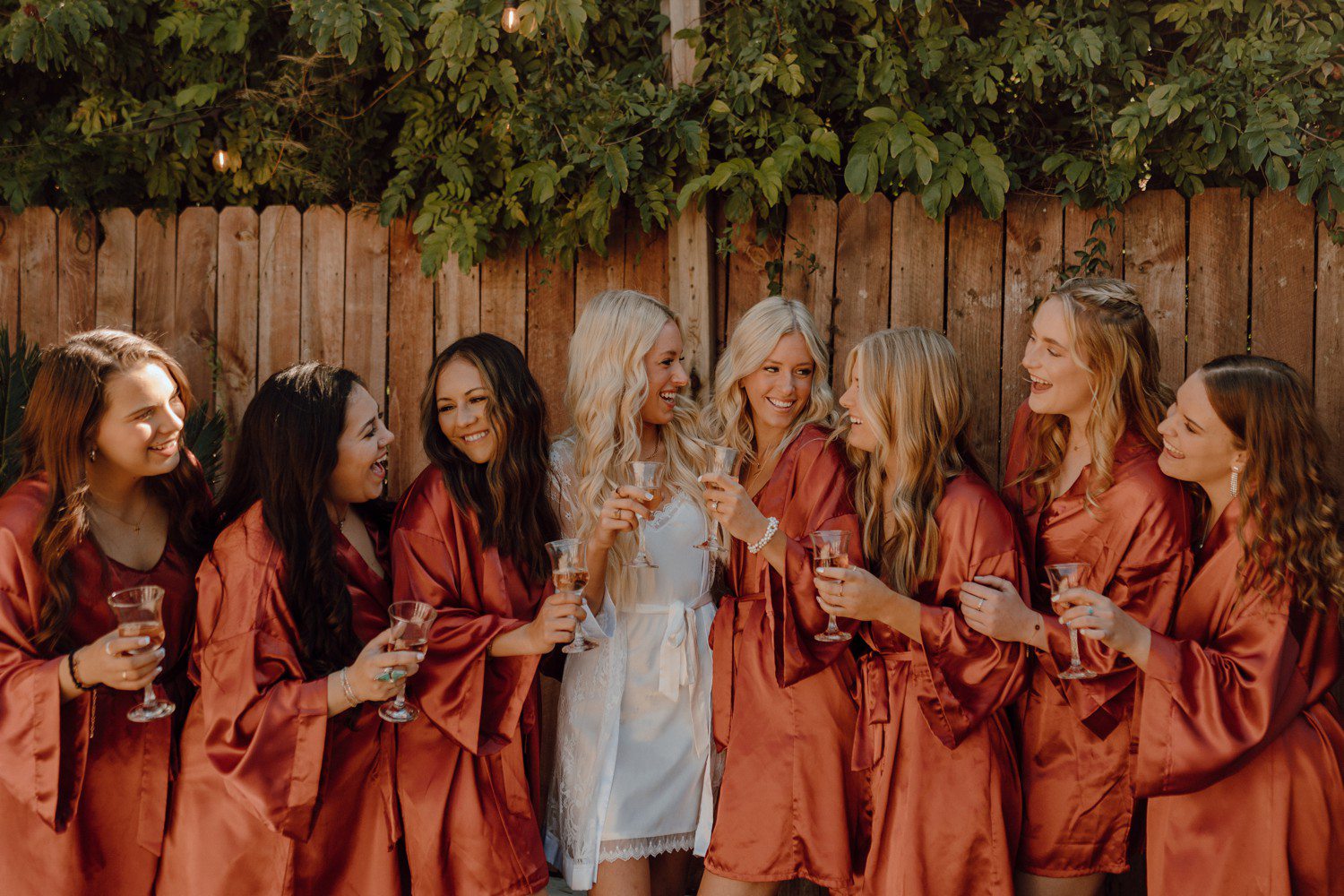 Bride and bridesmaids in burnt orange getting ready robes 