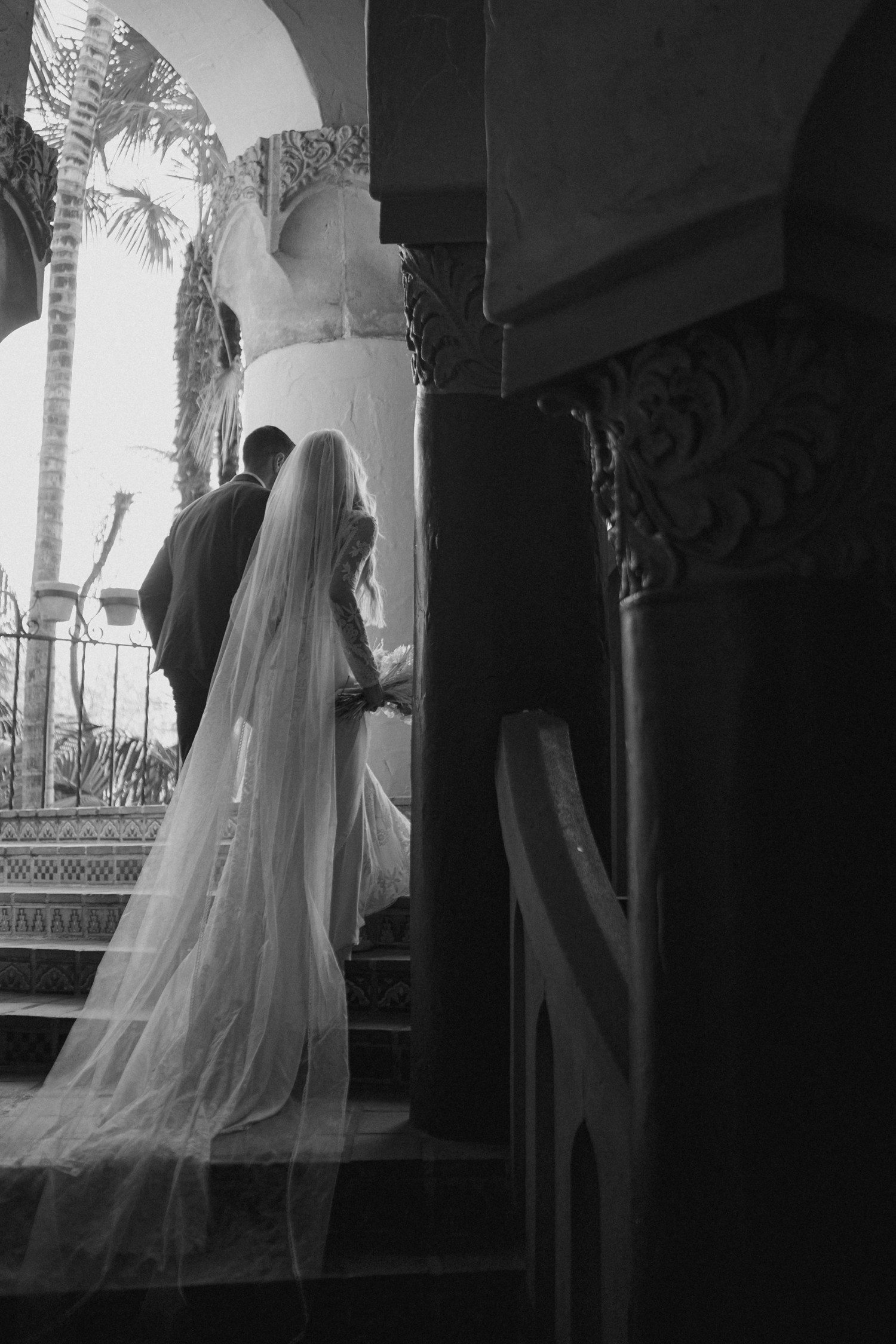 Bride and groom walking up stairs on Santa Barbara courthouse. 