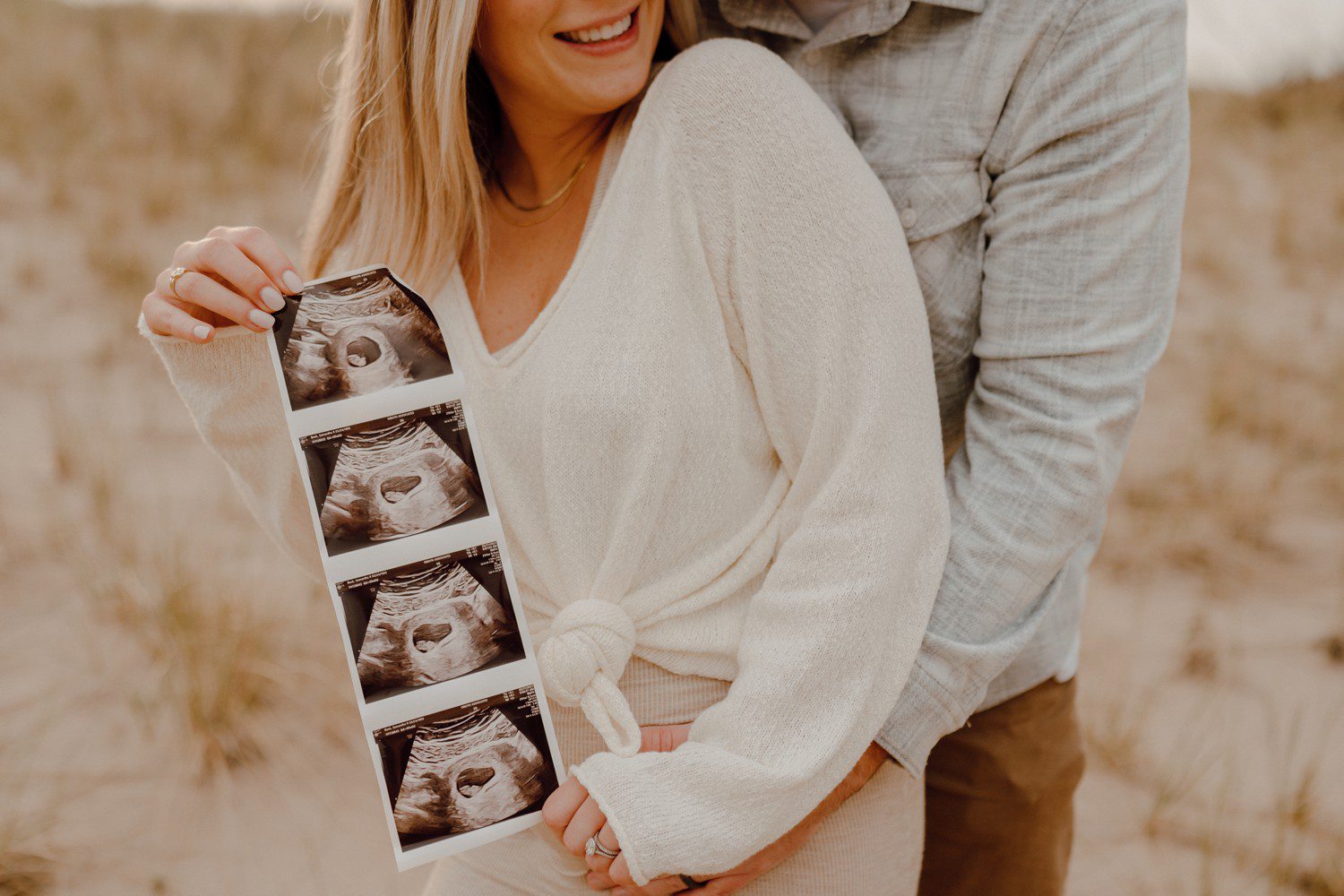 Pregnancy announcement photos with sonogram on the beach