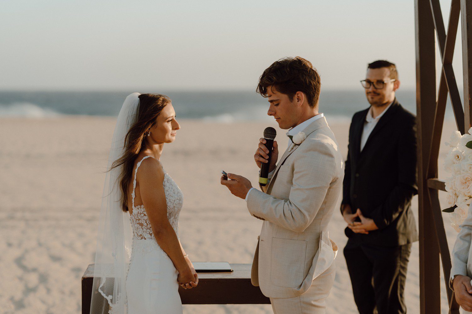 Groom reading vows during beach wedding in Los Cabos. 