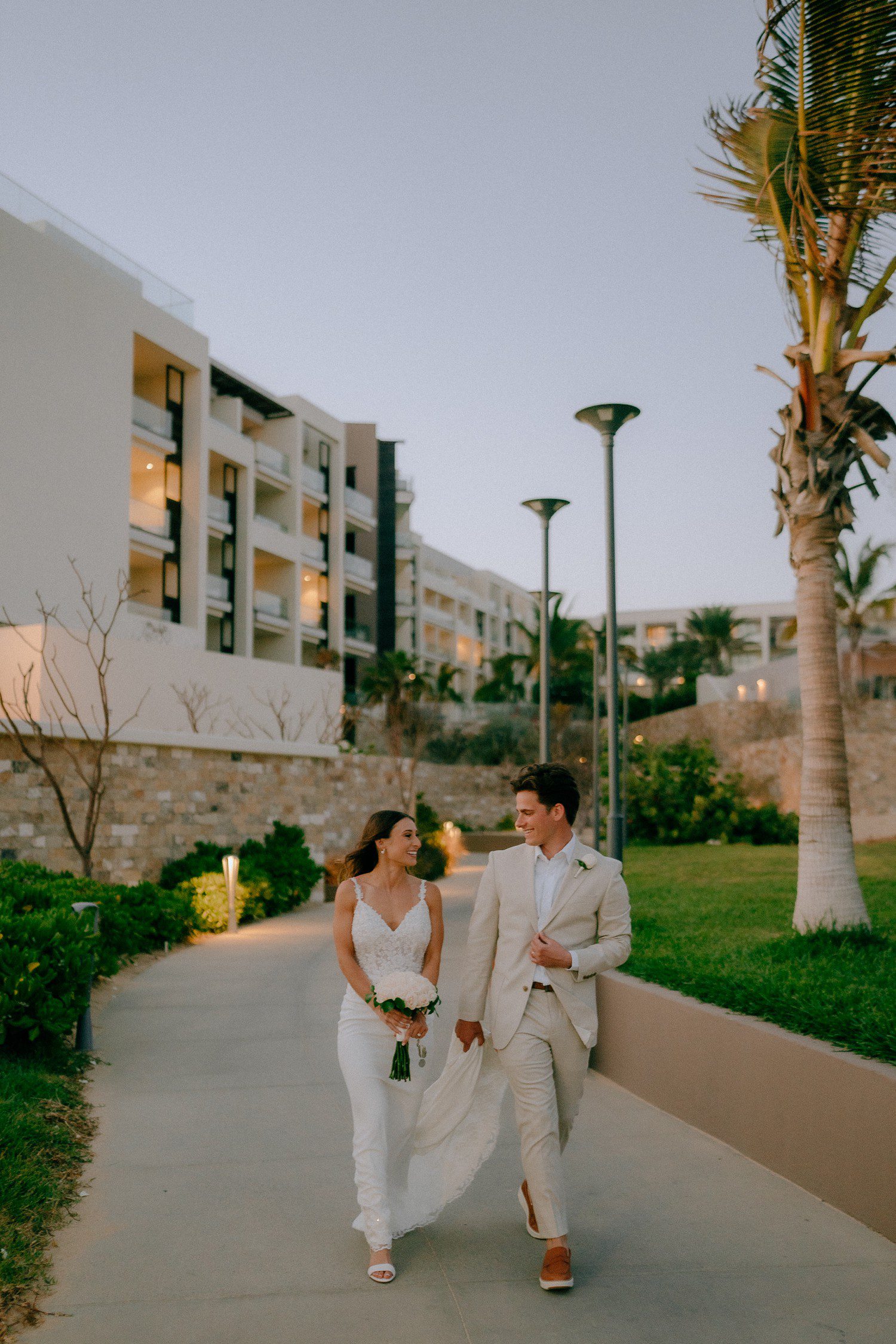 Bride and groom walking to wedding reception in Los Cabos. 