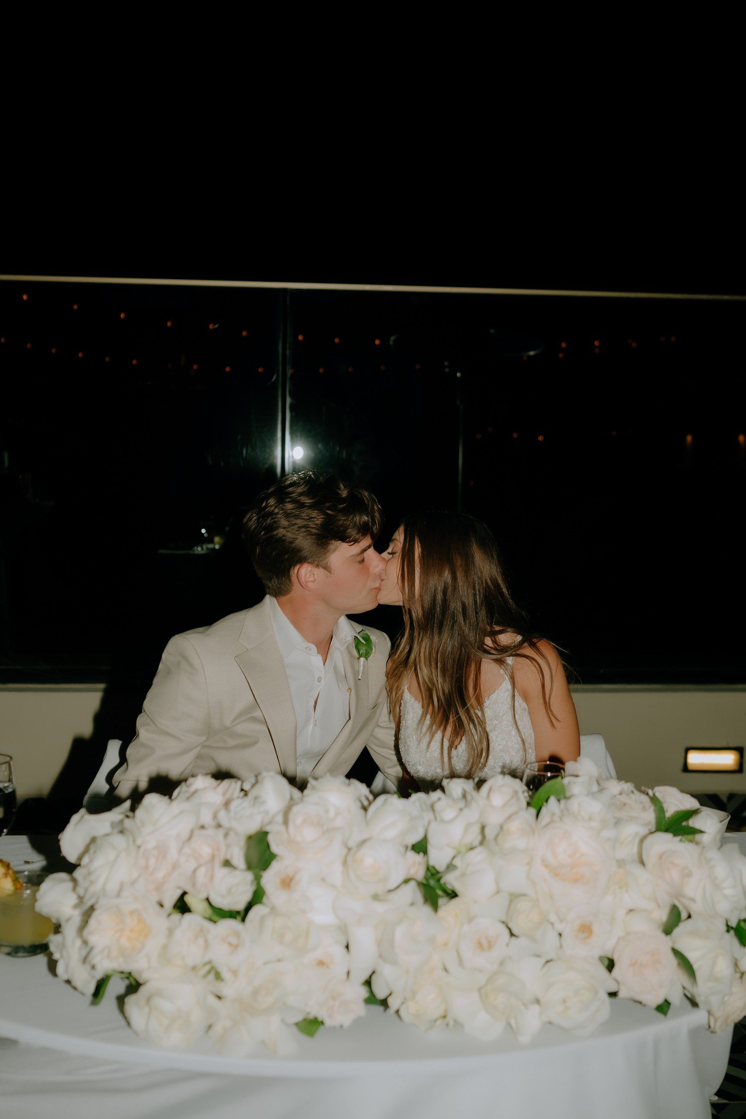 Bride and groom kissing during wedding reception in Los Cabos. 