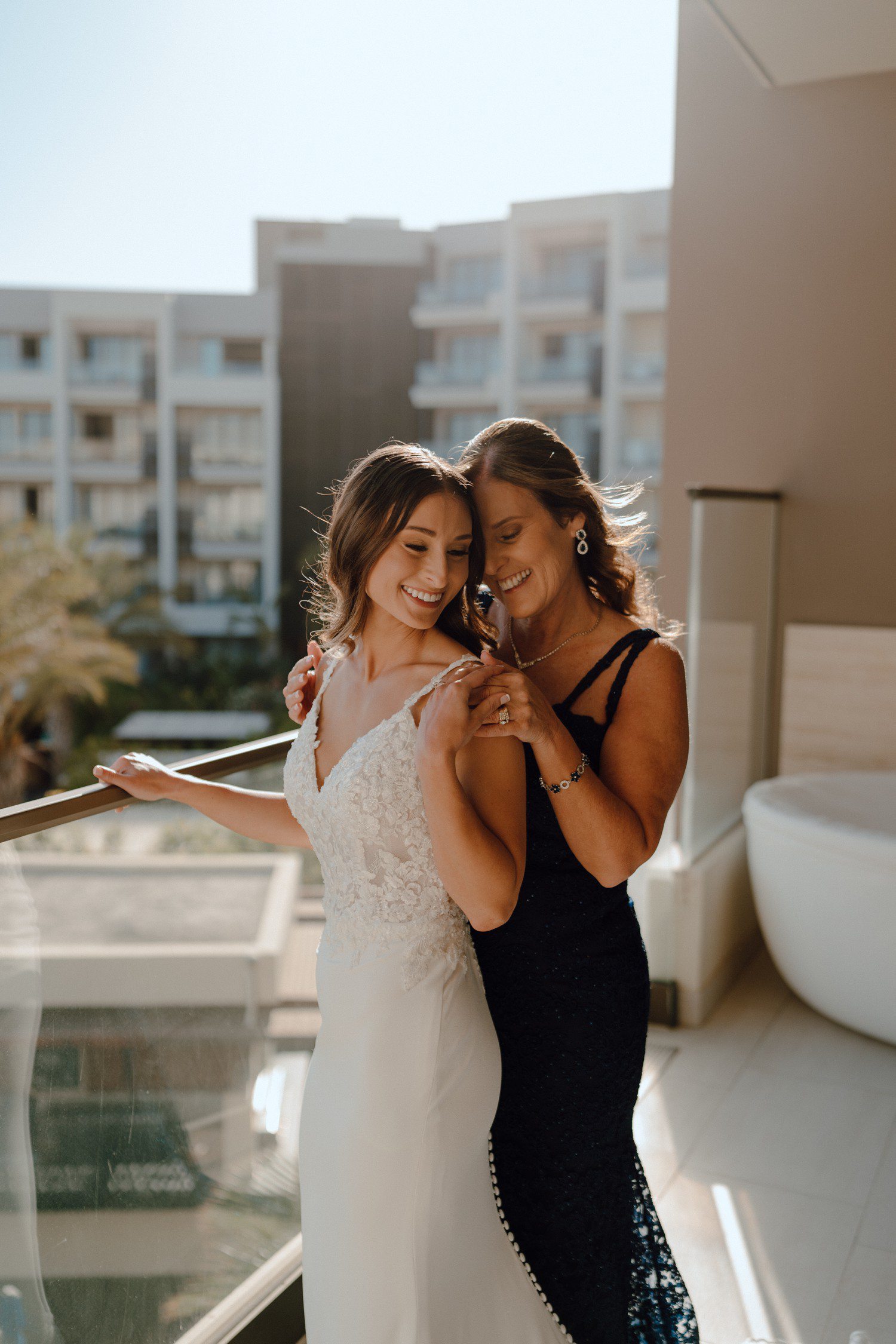 Bride and mom smiling together during getting ready at Los Cabos Hard Rock hotel. 