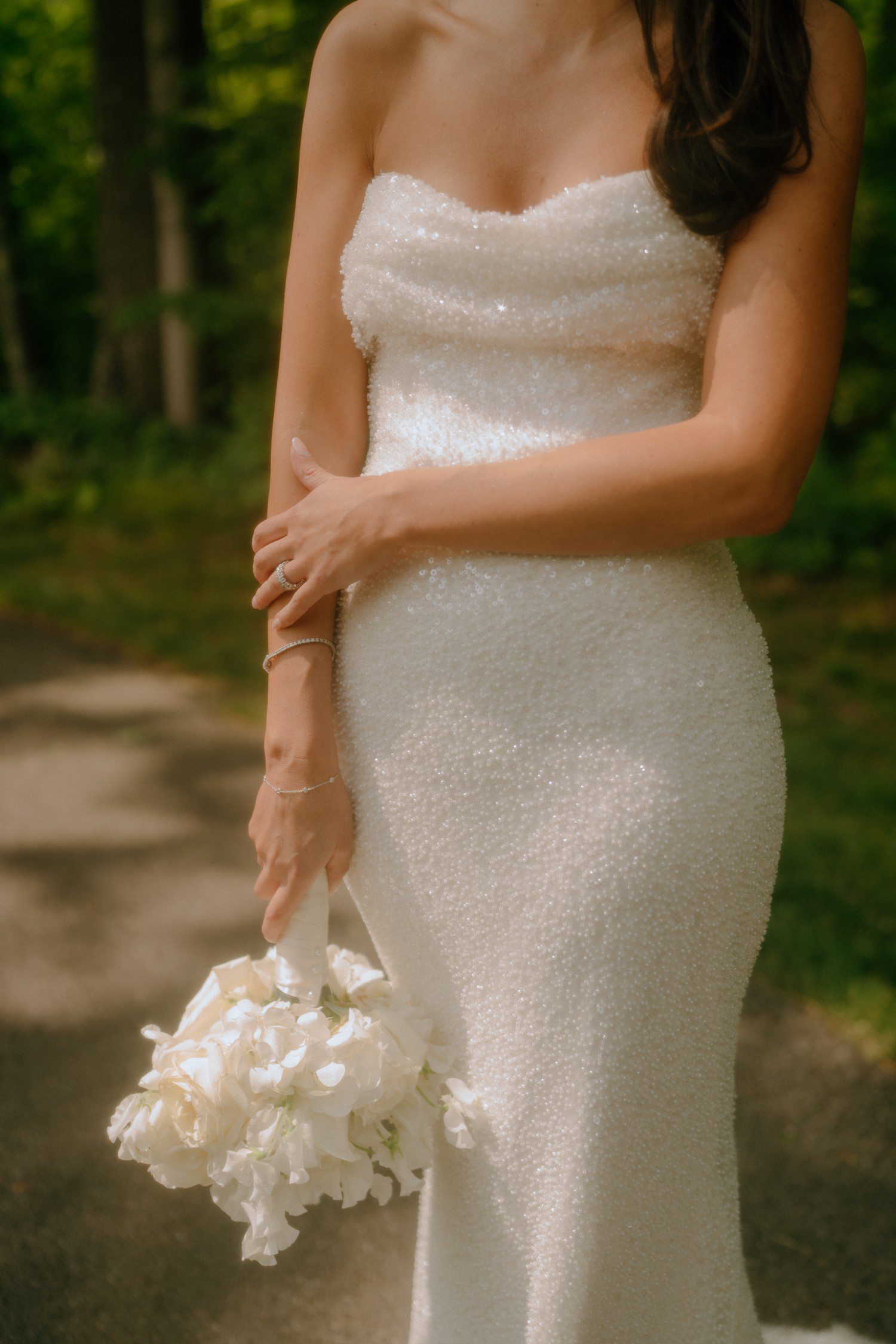 Bridal details of white bouquets and sparkly wedding dress. 