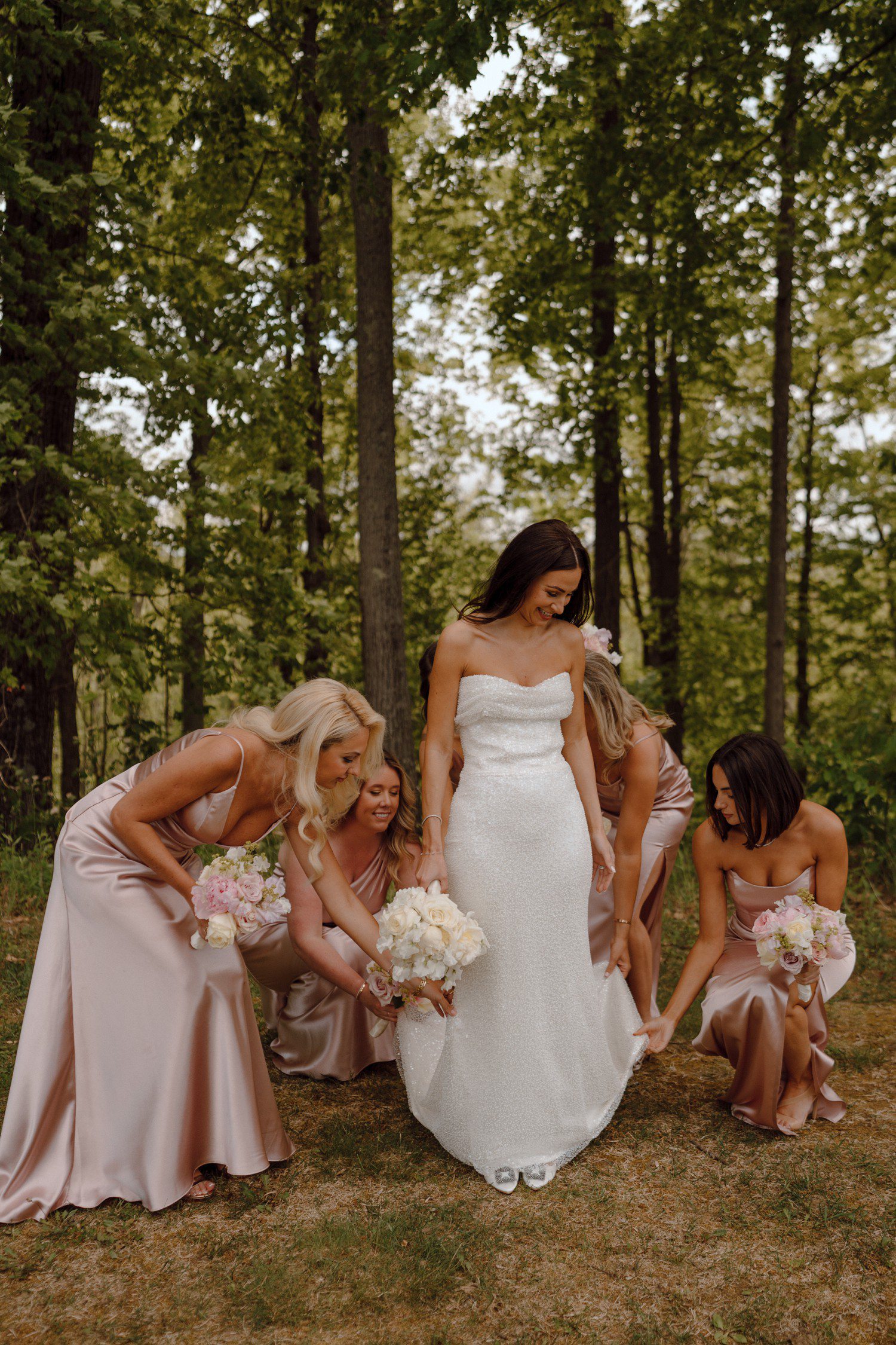Bride and bridesmaids helping fluff her dress. 
