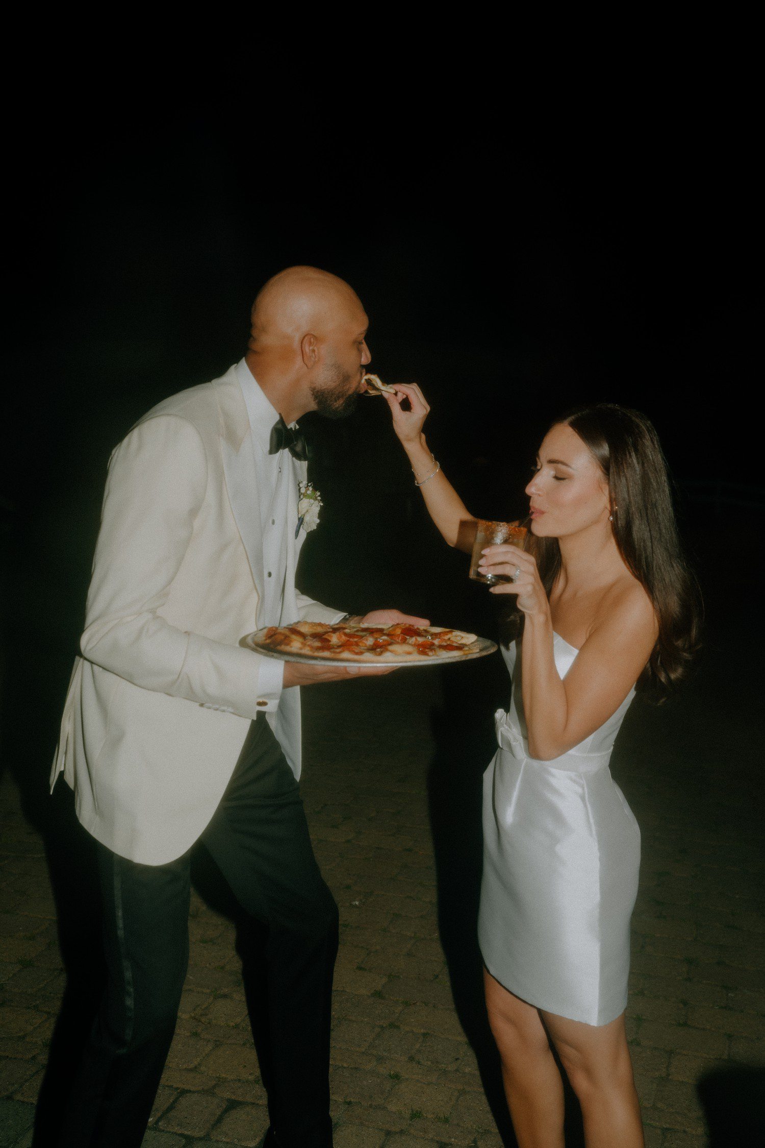 Bride and groom eating pizza together for wedding exit. 
