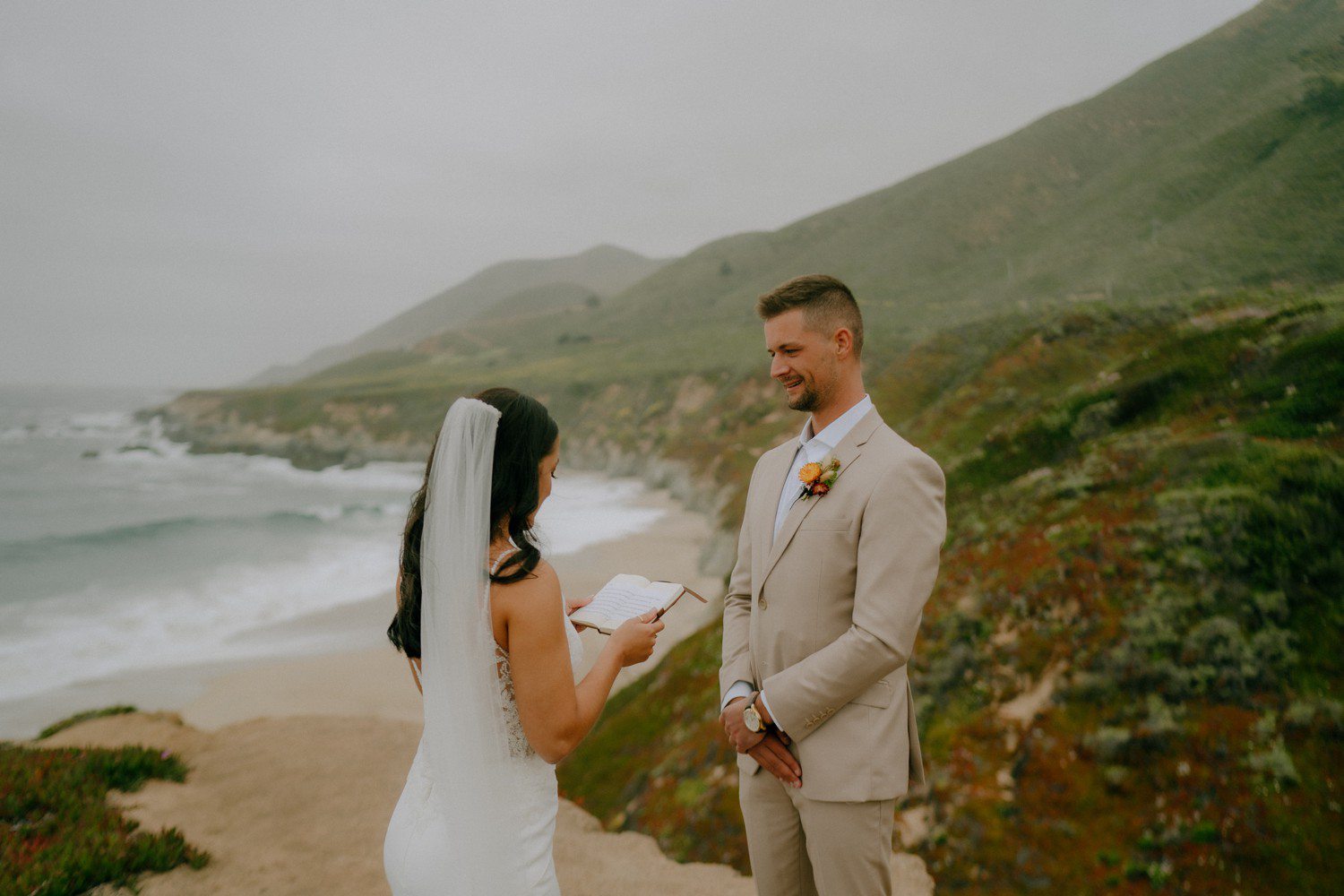Bride reading vows to groom on beach in Big Sur. 