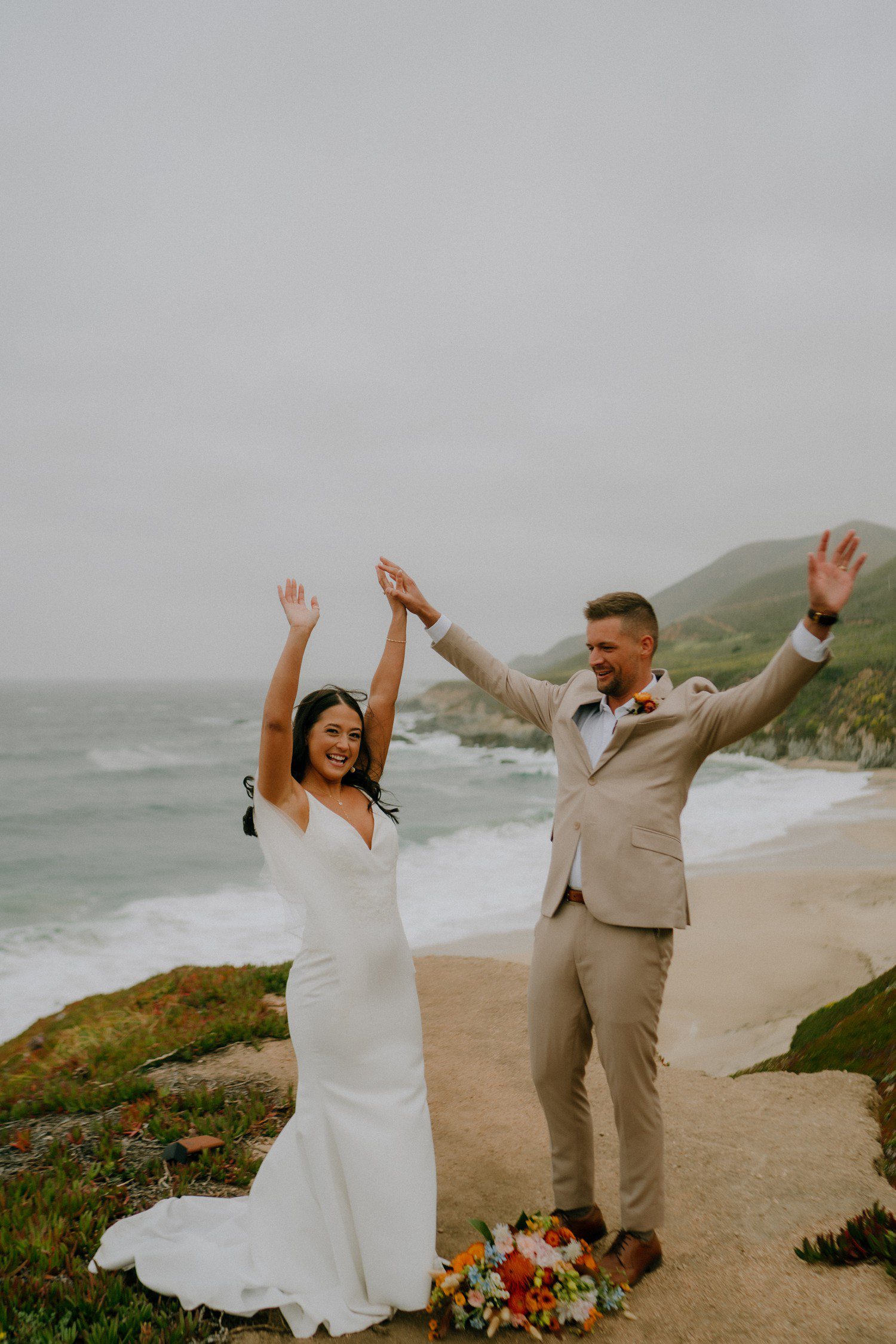 Couple celebrating eloping on the beach in Big Sur. 