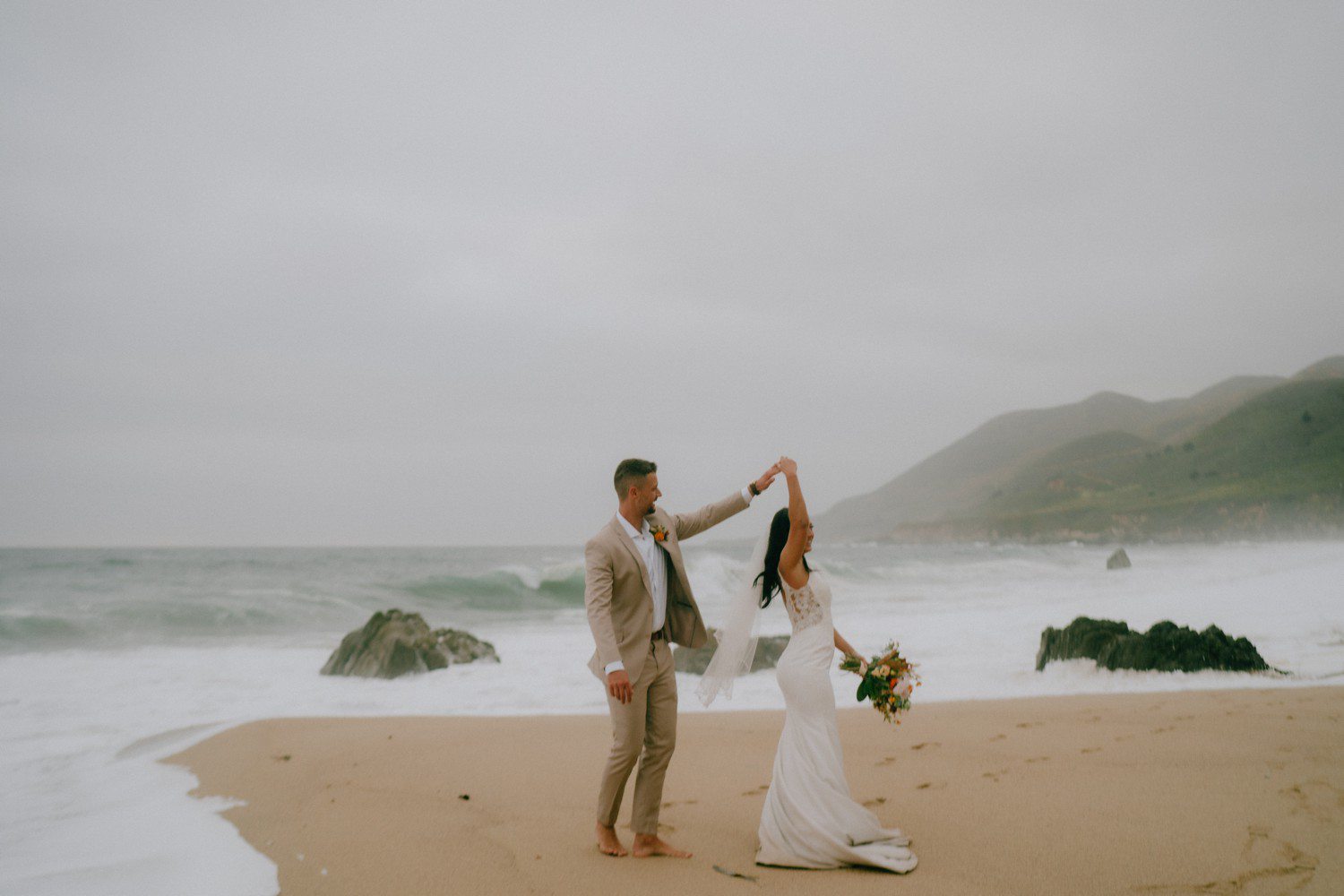 Wedding couple dancing on Garrapata Beach Big Sur. 