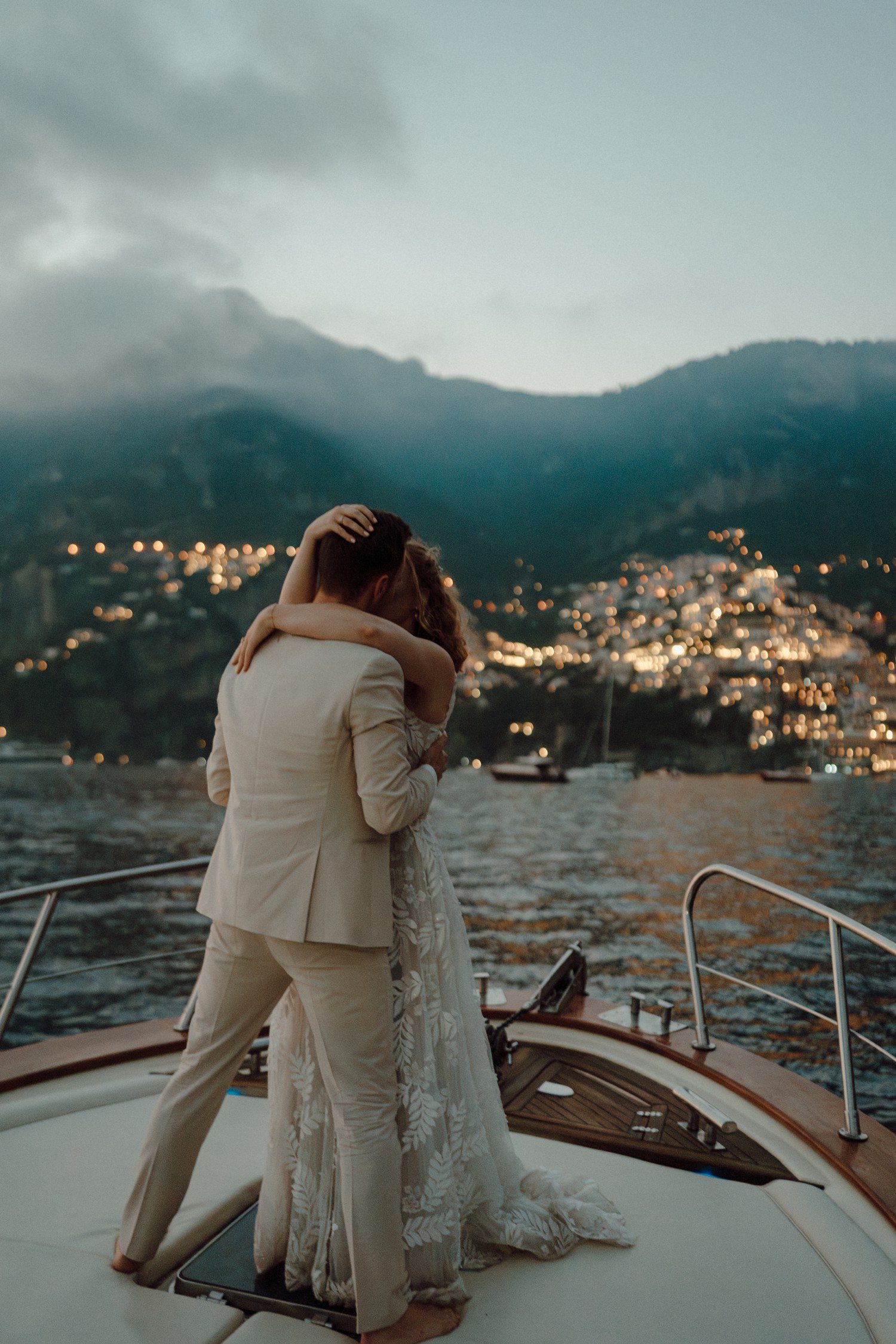 Couple hugging during elopement on a boat in Positano Italy. 