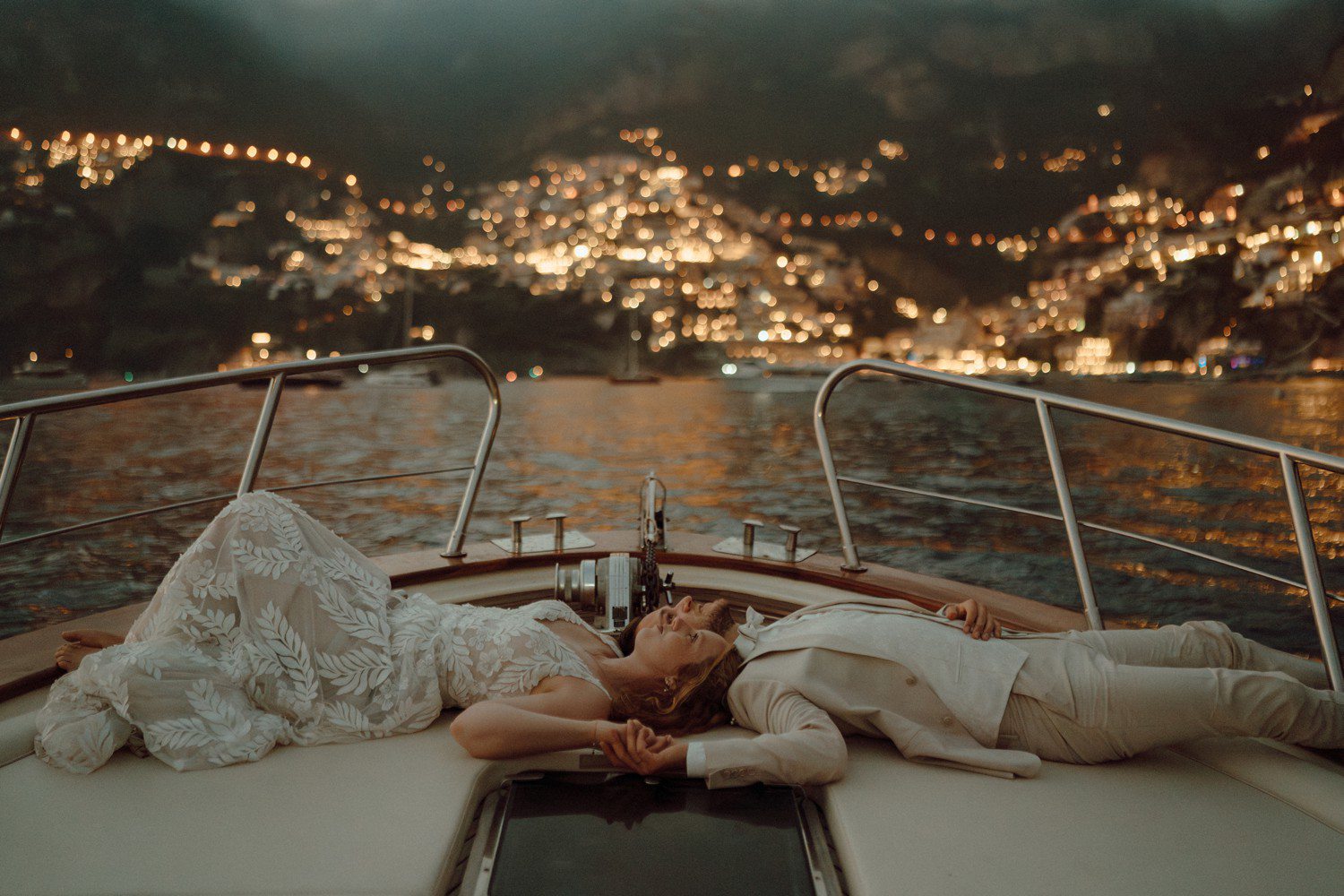 Couple lying on boat for elopement in Positano Italy.