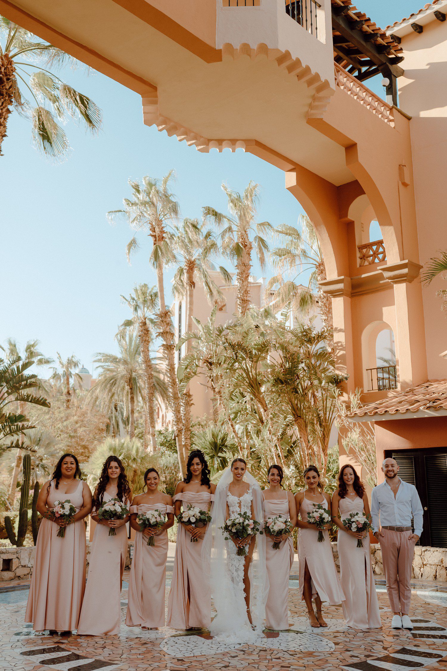 Bride and bridesmaids in light pink dresses at Hacienda Del Mar resort in Cabo. 