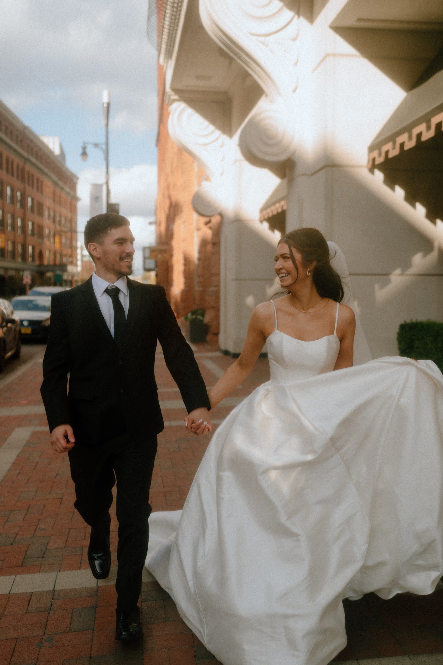Bride and groom running for elopement in downtown Grand Rapids, Michigan. 