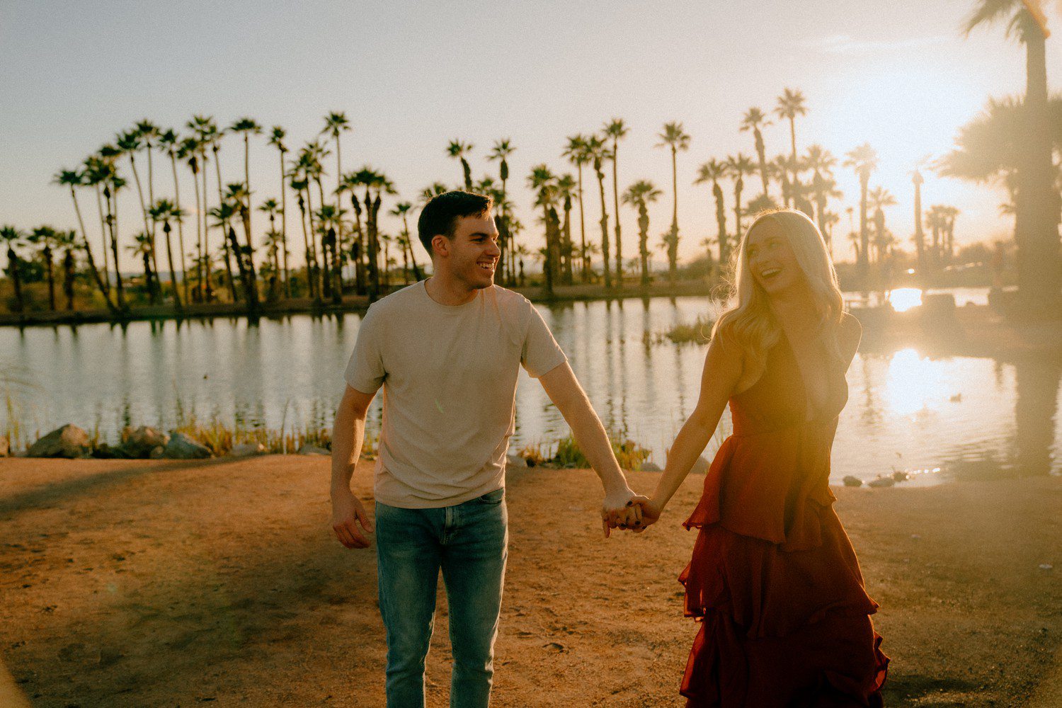 Couples photos at Papago Park with couple walking by a lagoon.