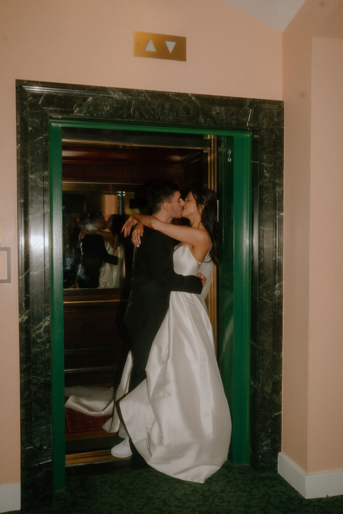 bride and groom kissing in an elevator