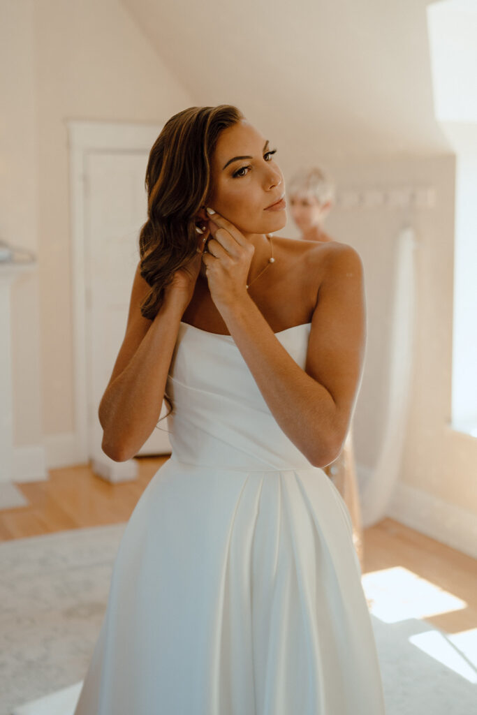 bride putting on her jewelry for her wedding ceremony