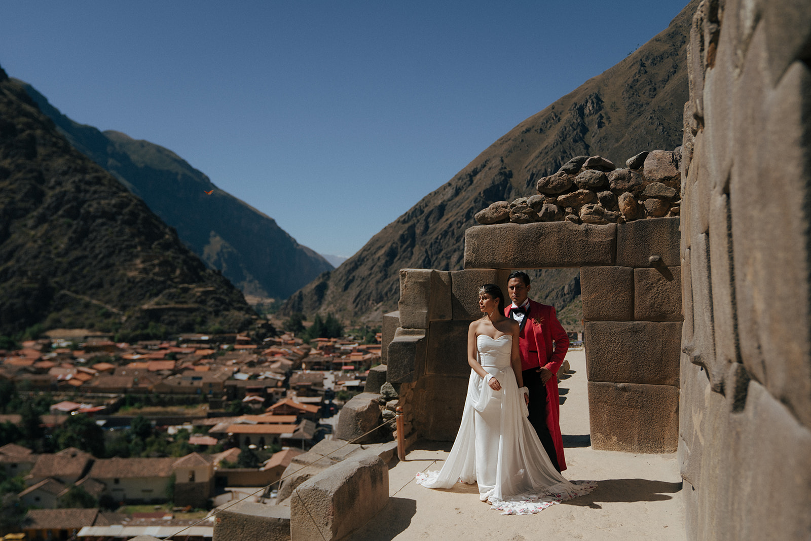 groom wearing a red tuxedo and bride wearing an amazing white gown