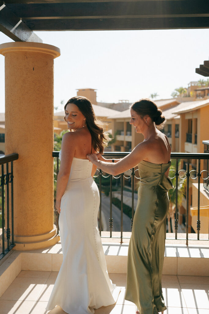 bridesmaid helping the bride with the wedding dress