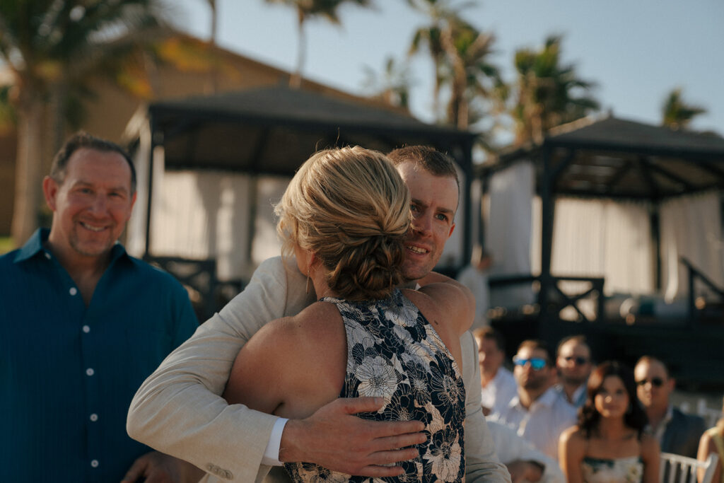 groom hugging his mom at the altar