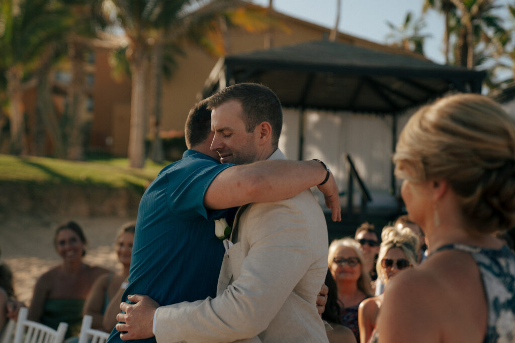 groom hugging his dad at the altar