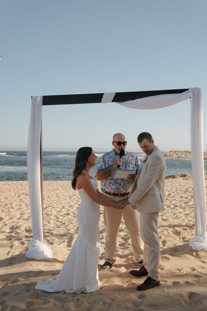 bride and groom holding hands at their timeless summer wedding ceremony