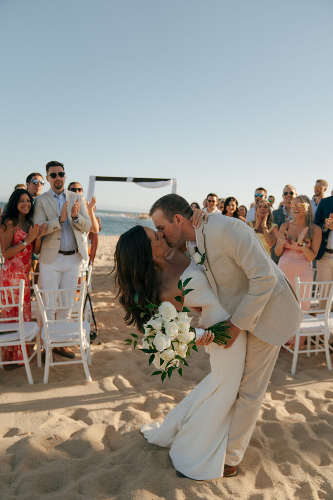 bride and groom kissing after their timeless summer wedding ceremony