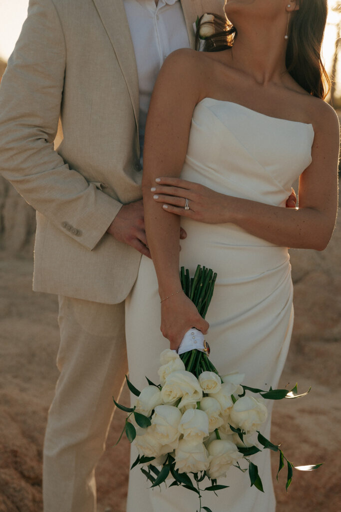 bride and groom hugging at their timeless summer wedding