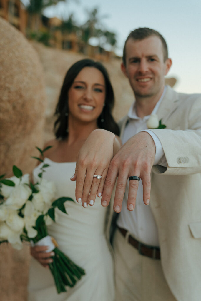 bride and groom showing their stunning wedding rings