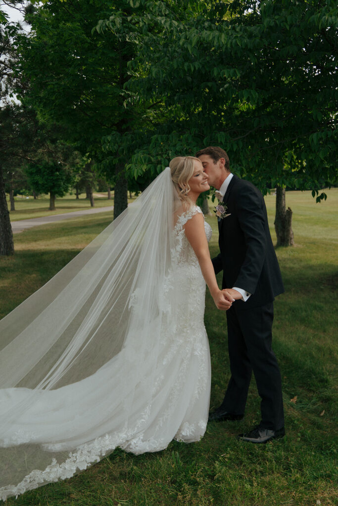 groom kissing the bride on the cheek after their wedding ceremony