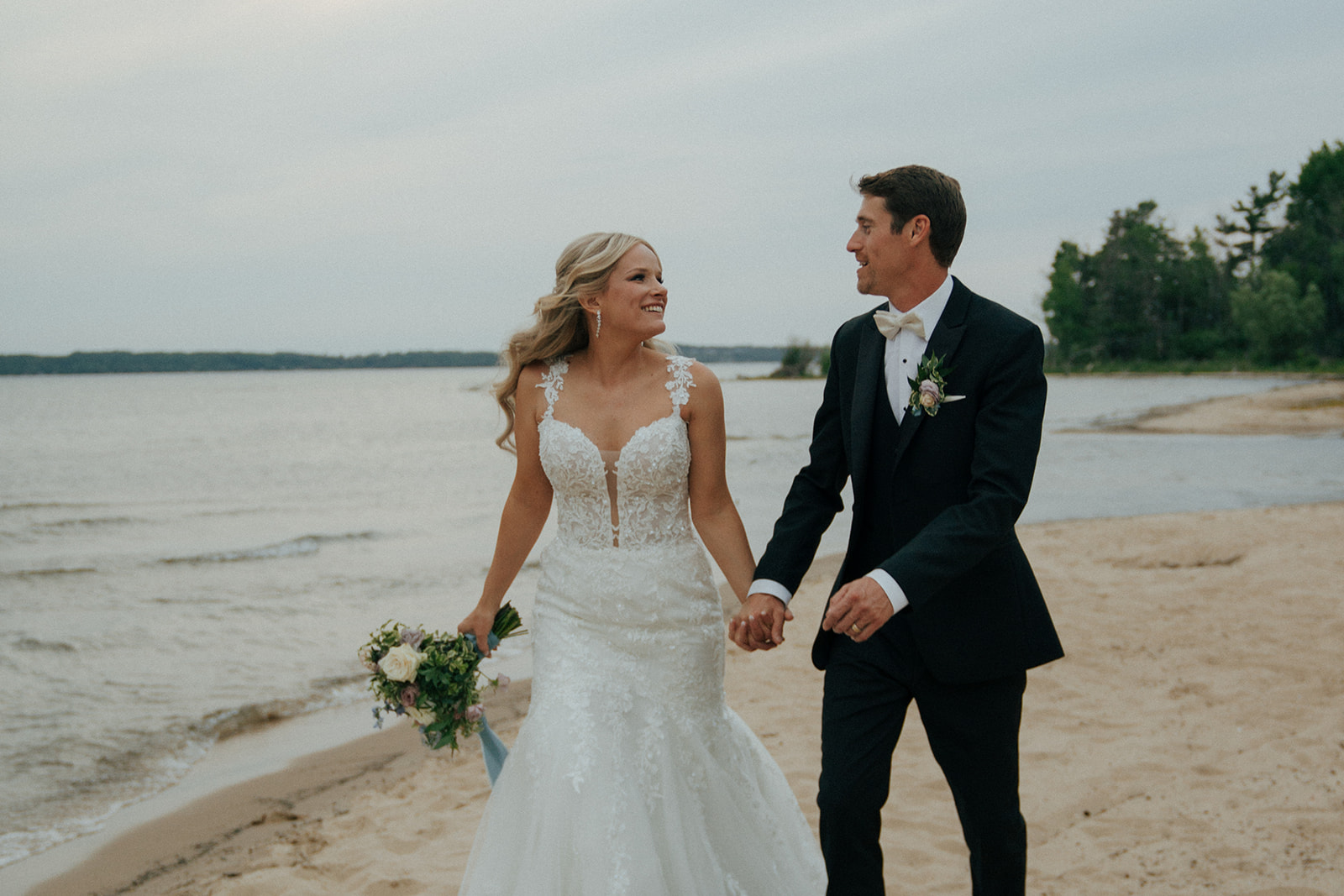 bride and groom walking around the beach