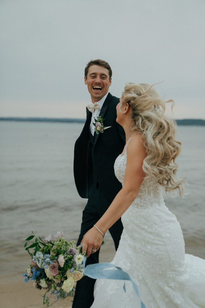 bride and groom running at the beach