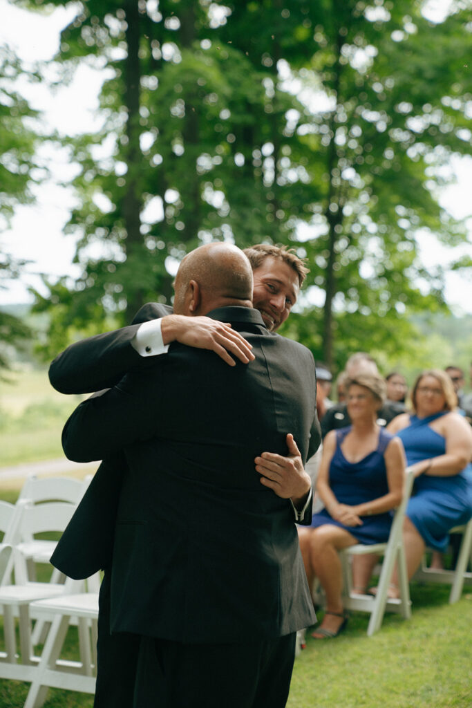 groom hugging his dad before the wedding ceremony