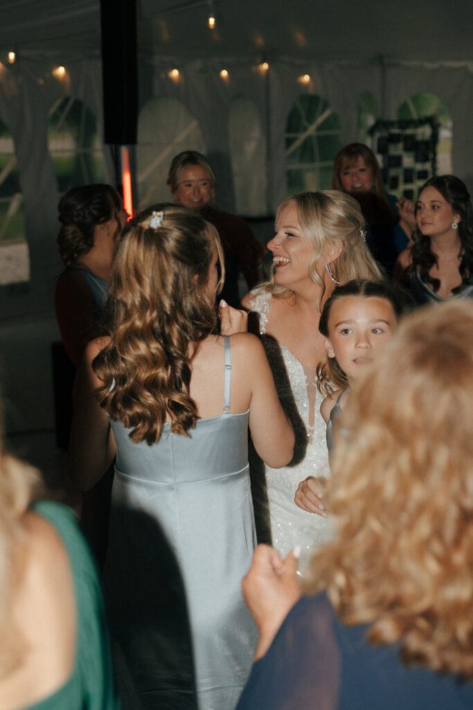 bride and her guests dancing at the wedding reception party