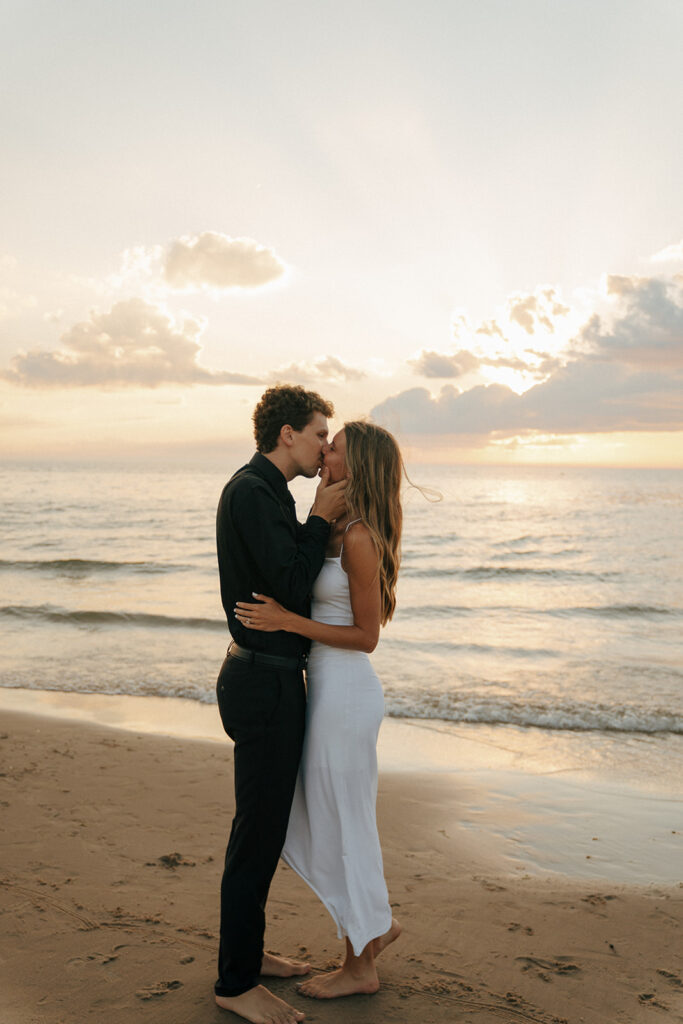 couple kissing at their engagement session in oval beach