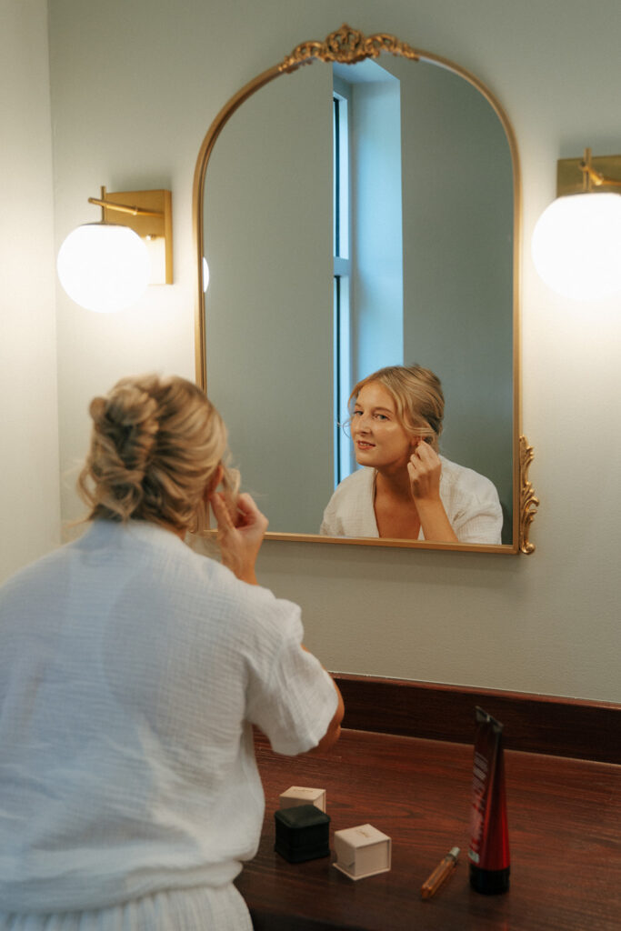 bride putting on her wedding earrings