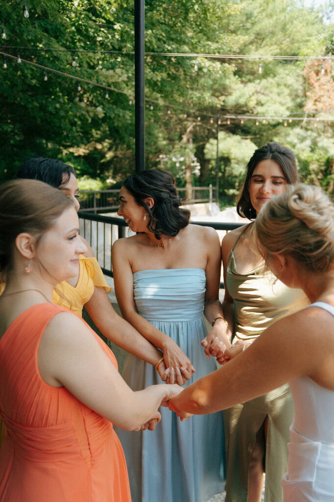 bride and her bridesmaids holding hands