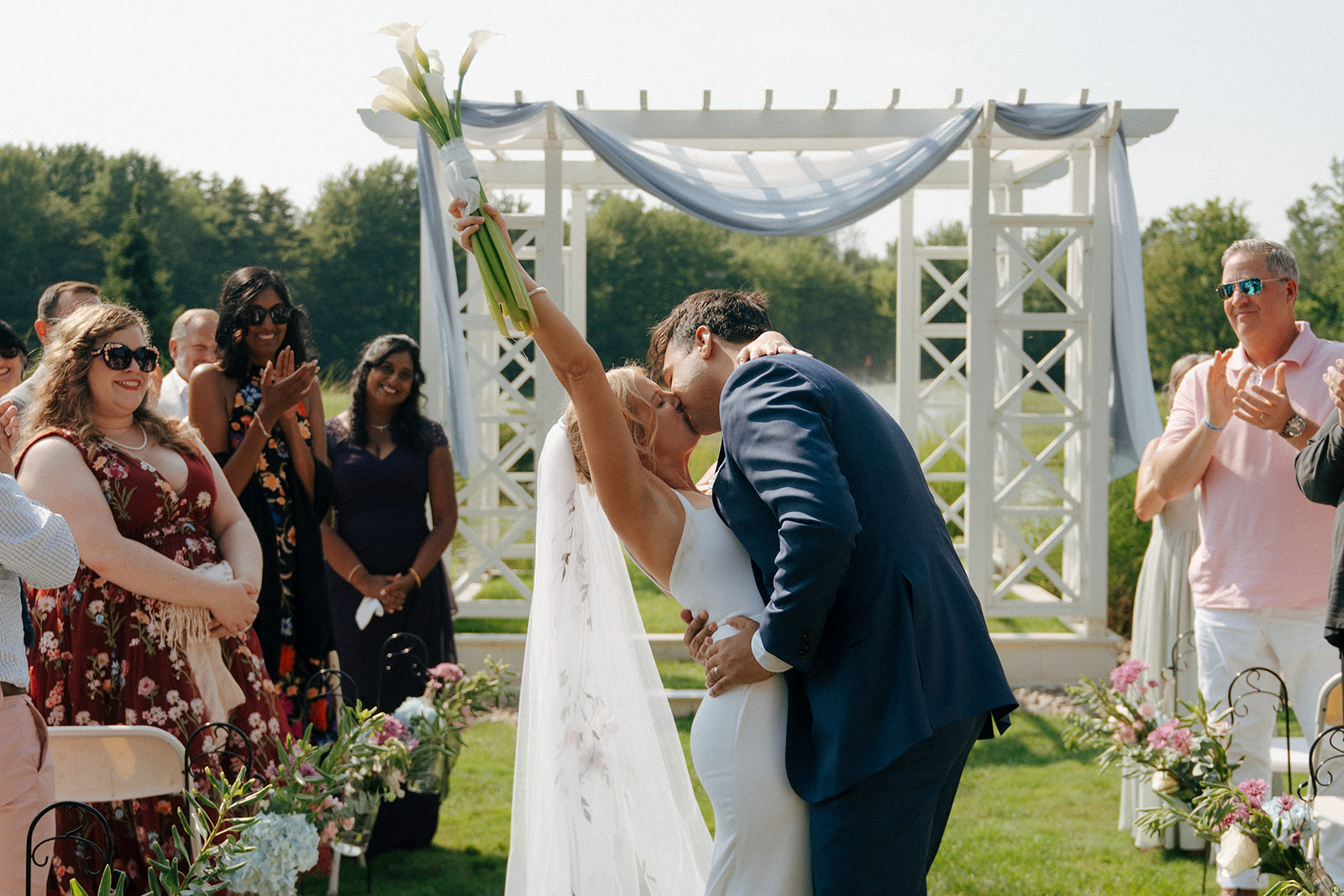 couple kissing after their summer wedding ceremony