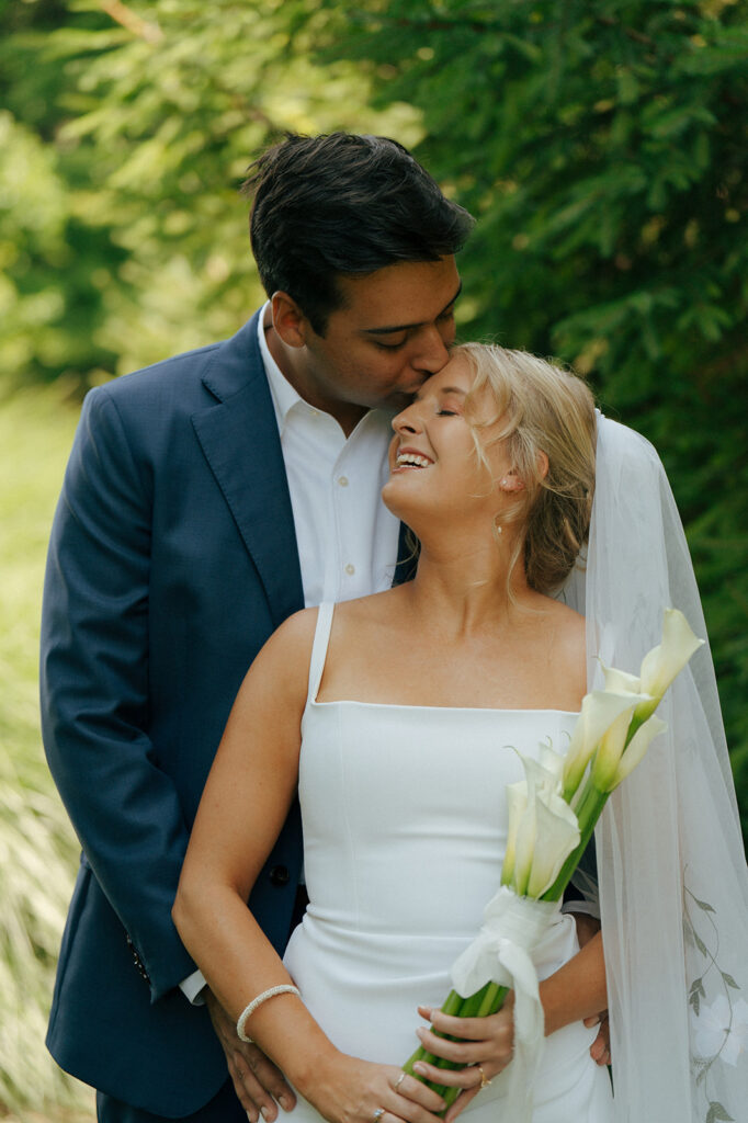 groom kissing the bride on the forehead