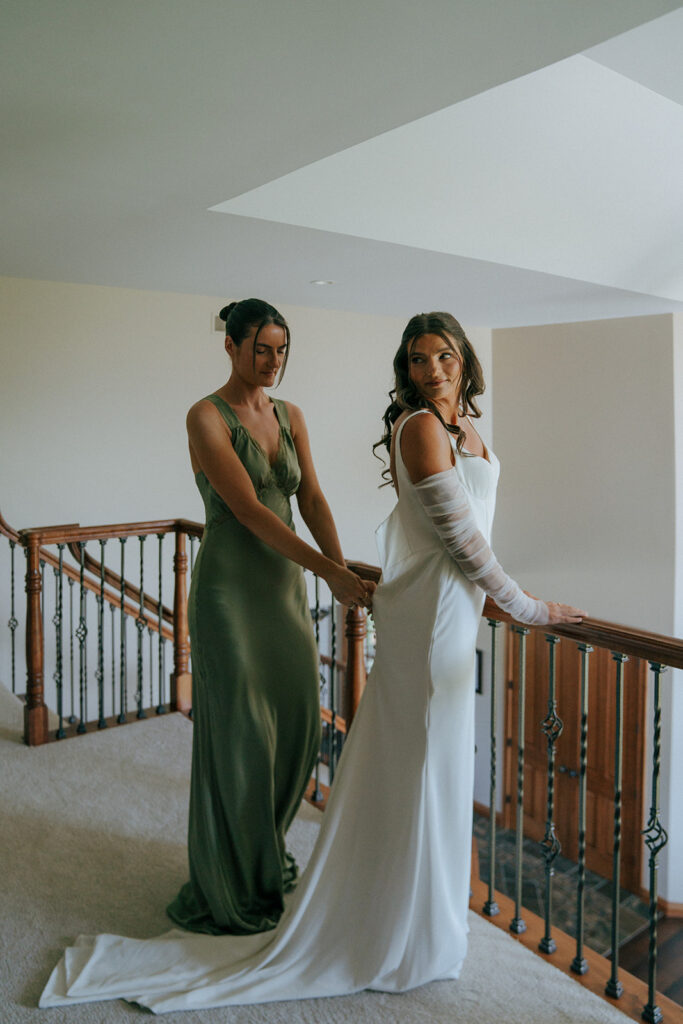 bridesmaid helping the bride with her wedding dress