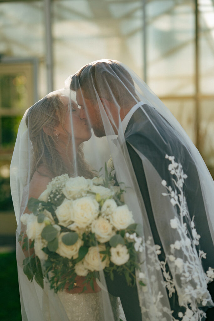 portrait of the bride and groom kissing at their timeless wedding