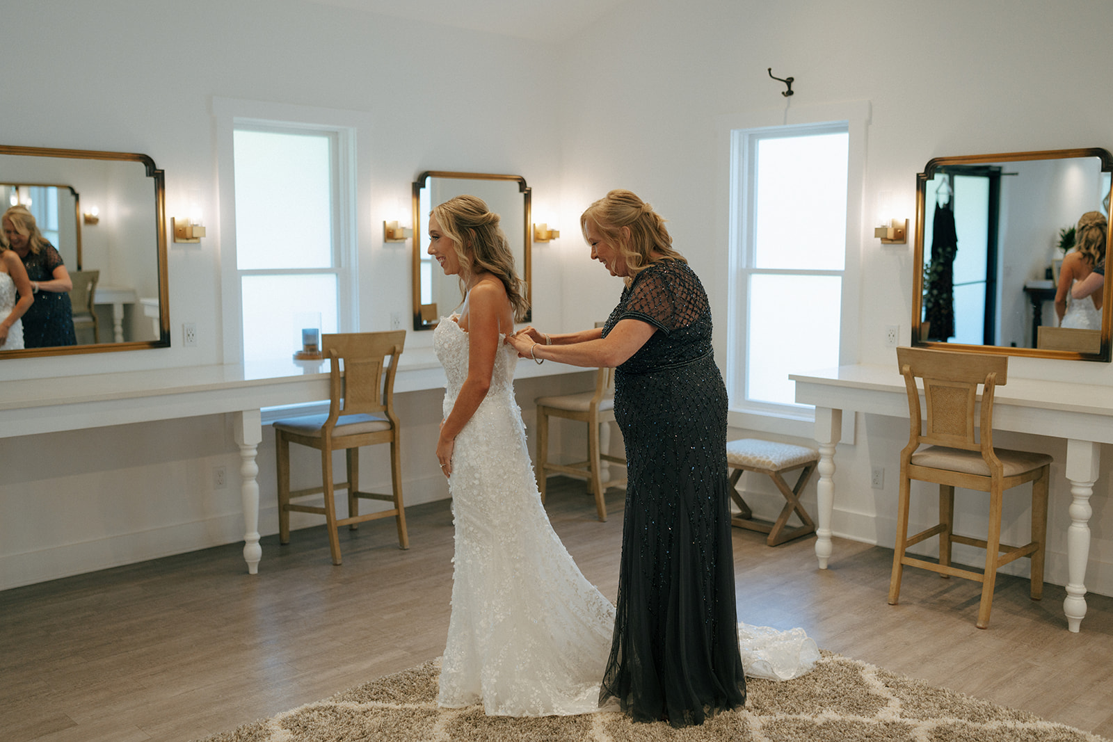 mother of the bride helping her with her wedding dress