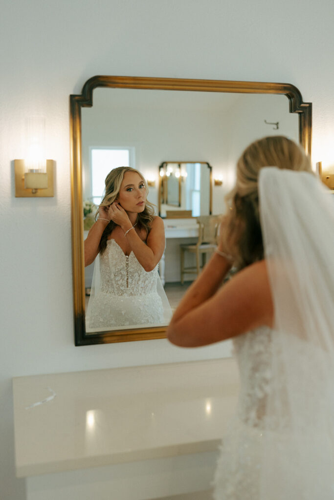 bride putting on her jewelry for her wedding ceremony