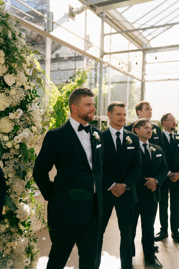 groom watching the bride walk down the aisle