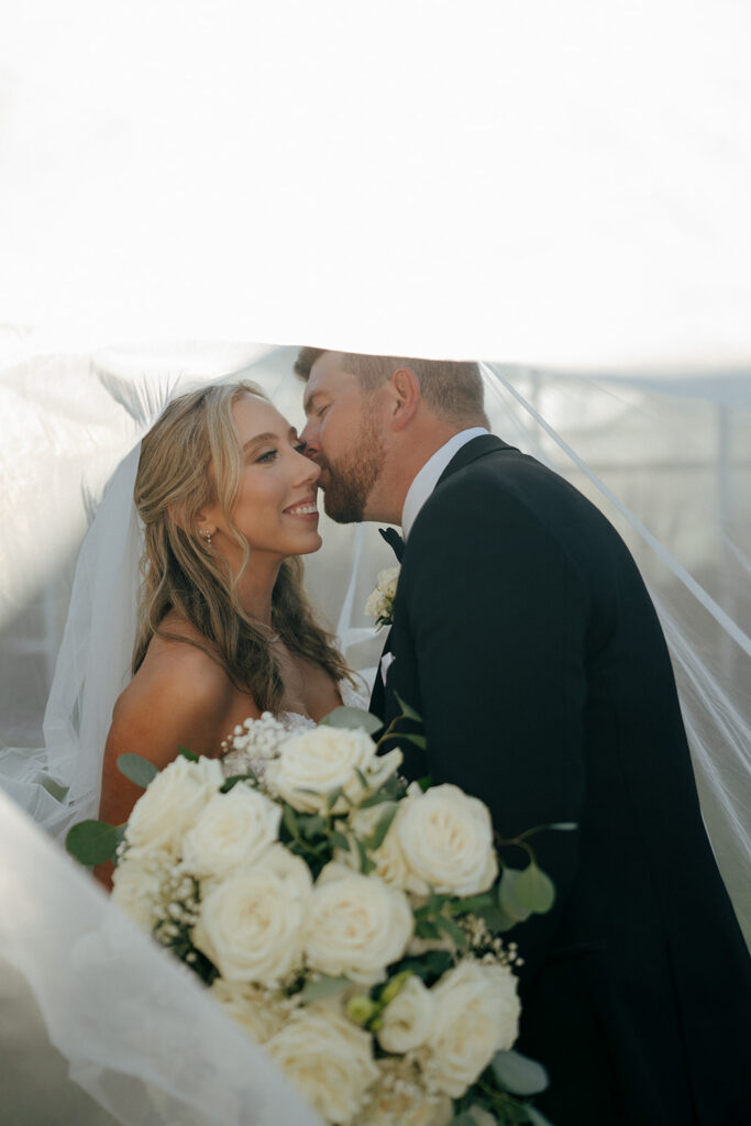 groom kissing the bride on the cheek