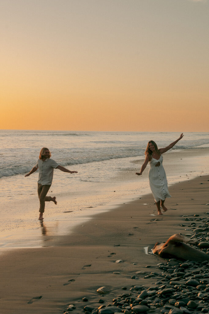 couple playing at the beach during their golden hour session