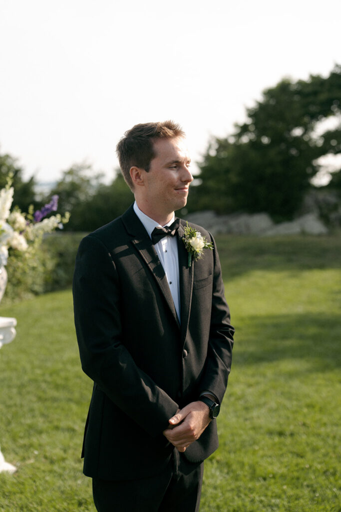 Groom watching the bride walk down the aisle