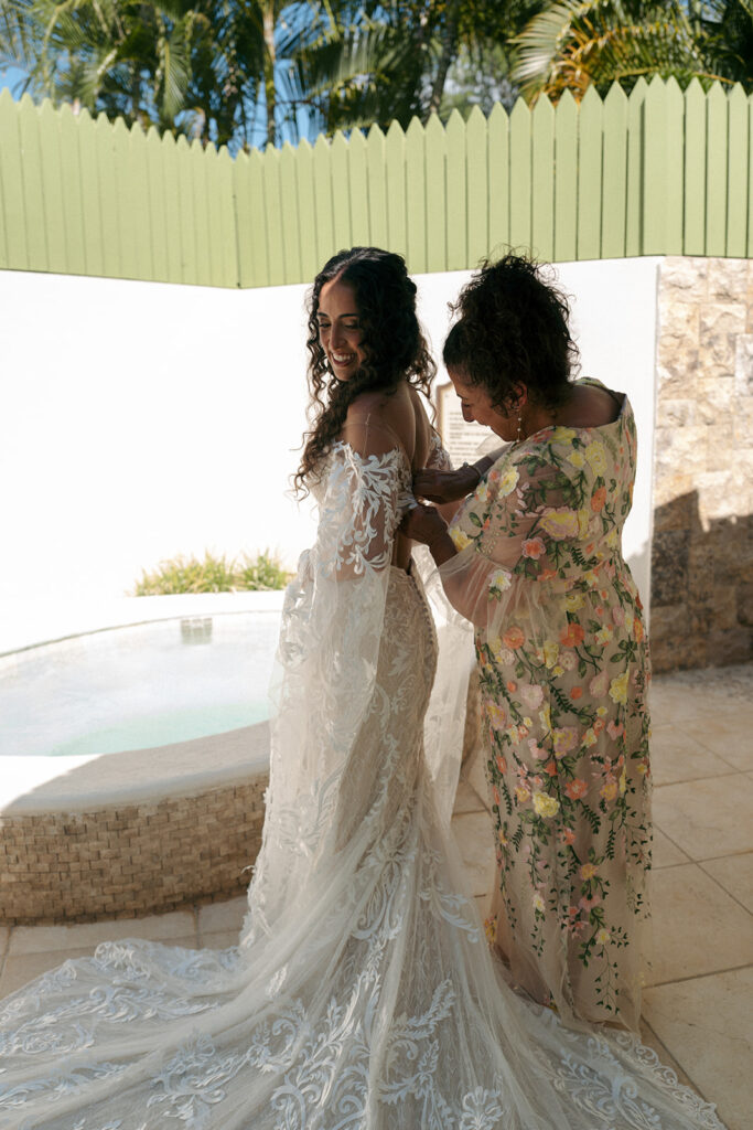 mother of the bride helping her with her wedding dress